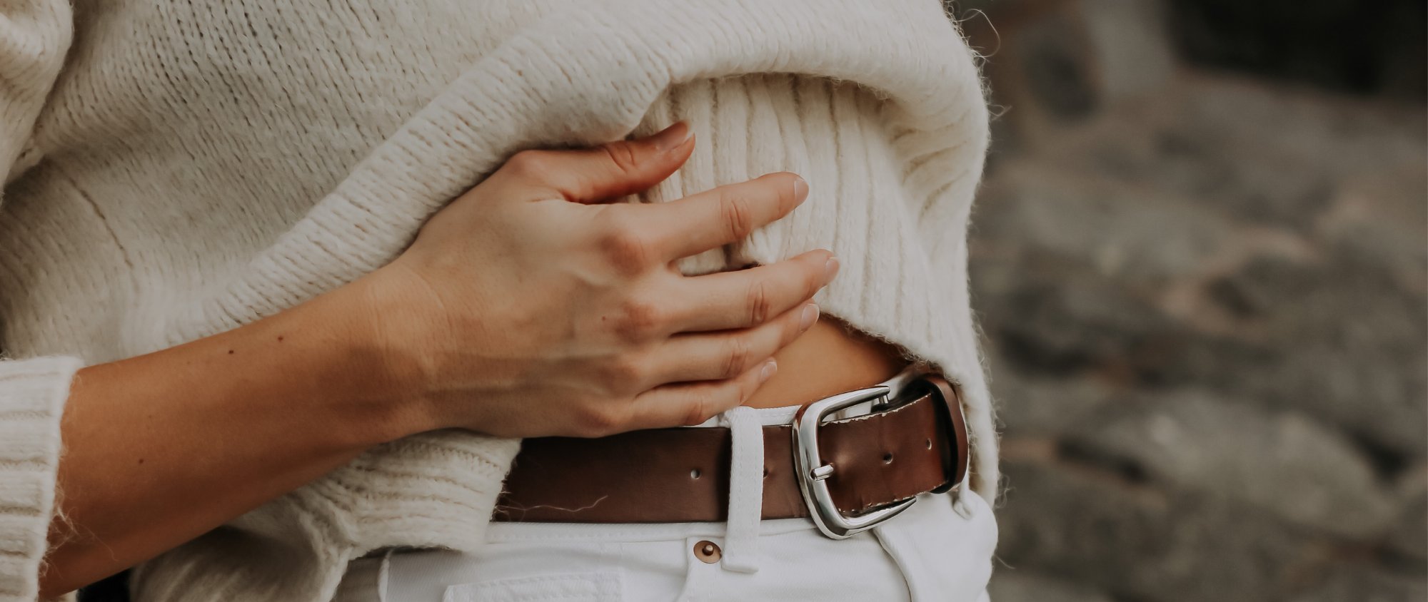 Person hält schützend die Hand auf den Bauch.