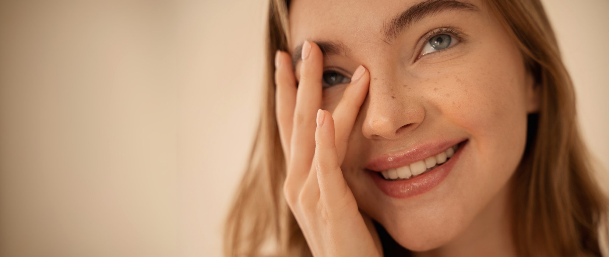 Lächelnde Frau mit gepflegten Lippen berührt sanft ihr Gesicht.