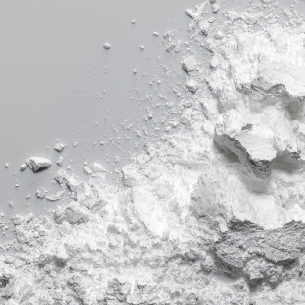 Helles, fein gemahlenes Mineralstoff-Pulver auf blauer Fläche.