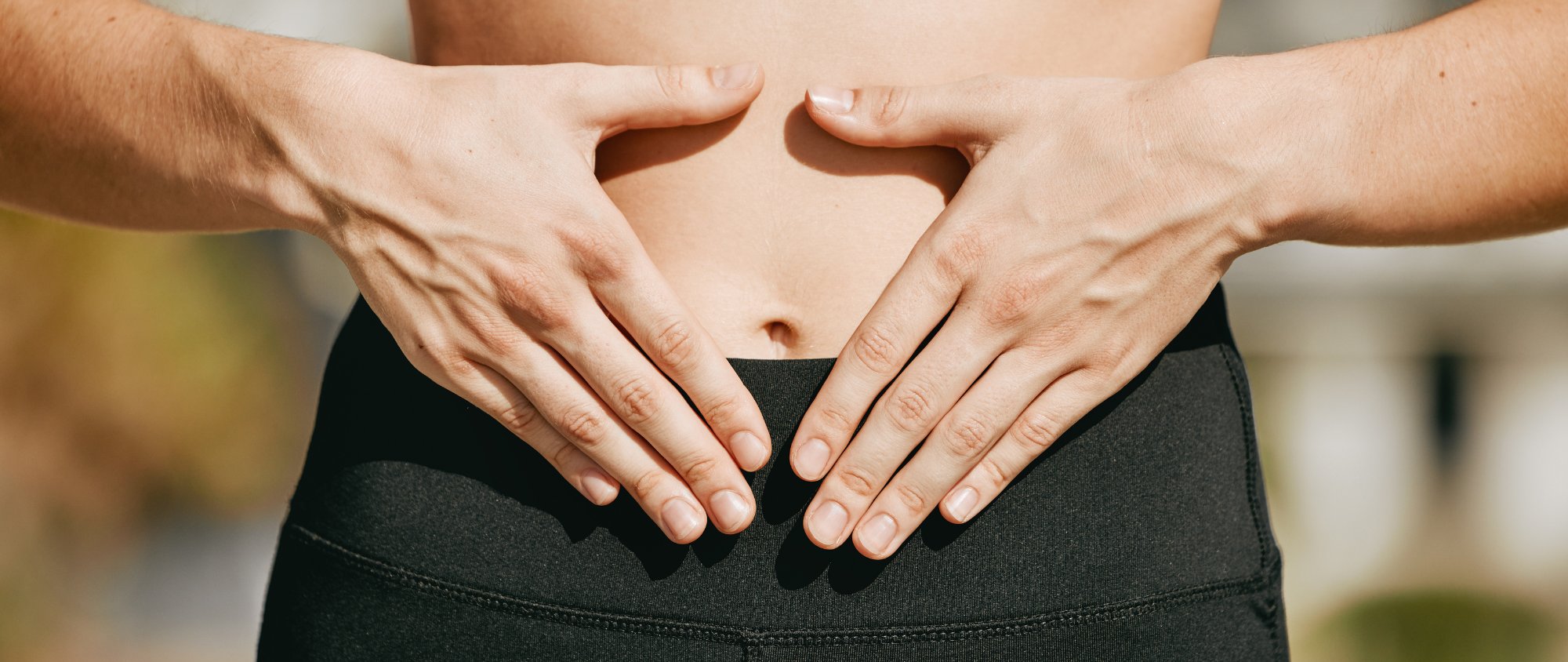 Person legt beide Hände in Herzform auf den Bauch.