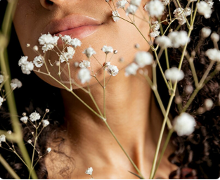 Unterer Teil des Gesichts eines Mädchens mit weißen Blumen